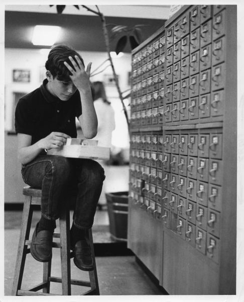 young boy looking through card catalog circa 1970