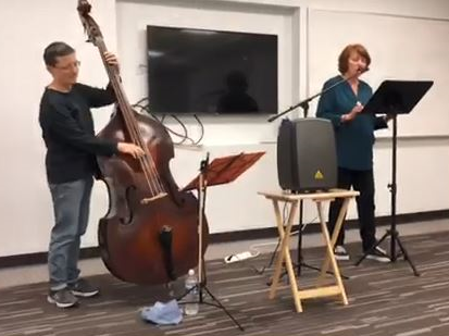 Heather Grant reading poetry with Chris Kosky playing bass